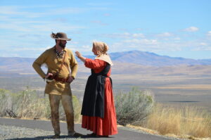 Pioneers on the Oregon Trail appear to be arguing about which way is west 